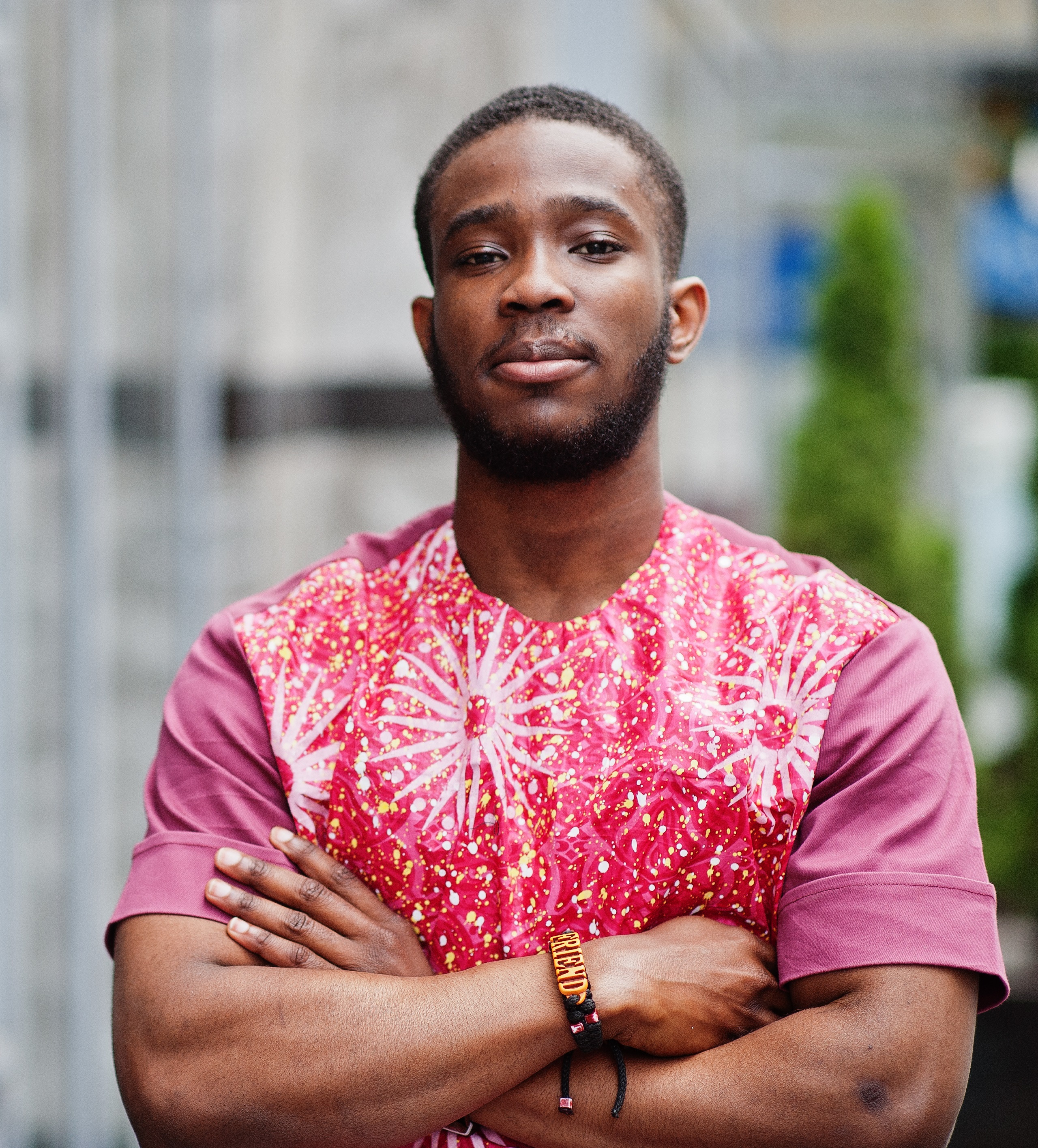 Portrait of a black young man wearing african traditional red colorful clothes.